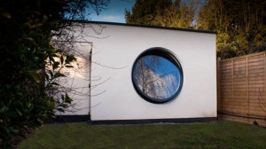 Large open circular aluminium window in wall of white building