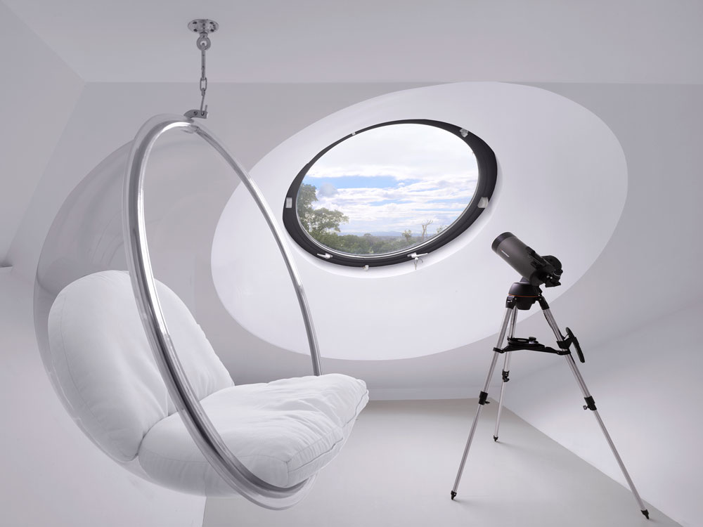 Contemporary room with hanging seat and large round aluminium window
