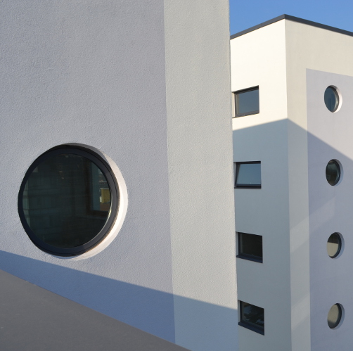 Round and rectangular aluminium windows in modern white building