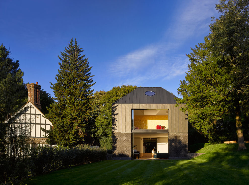 Contemporary house with large open floors and round aluminium window in roof